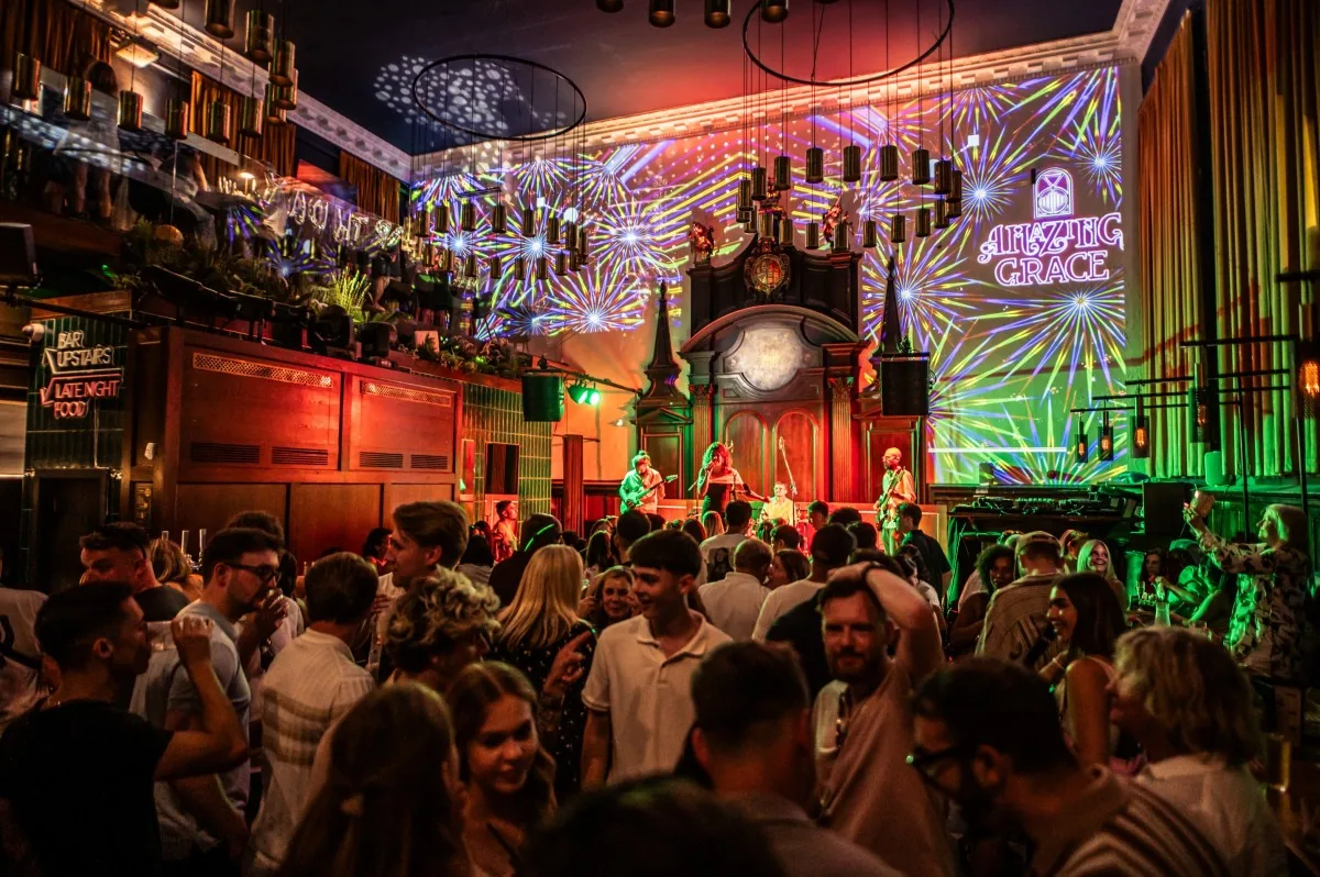 Busy venue with a live band and colourful stage lighting